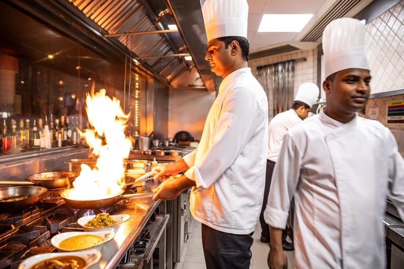 Chef cooking flambe dish kitchen Kolkata catering