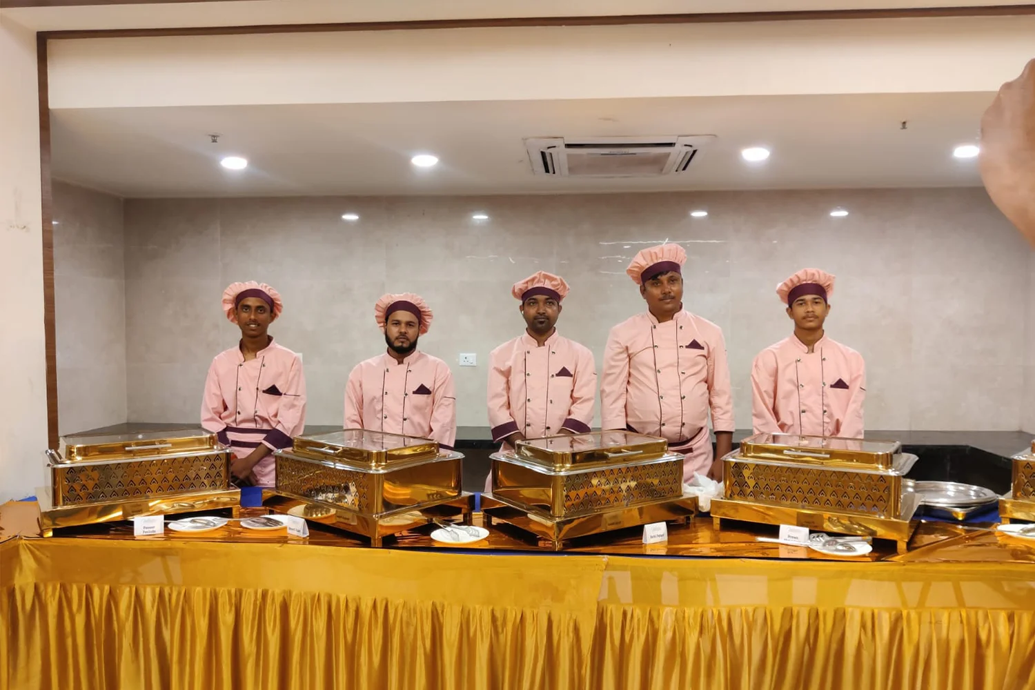 Catering staff in pink uniforms serving buffet