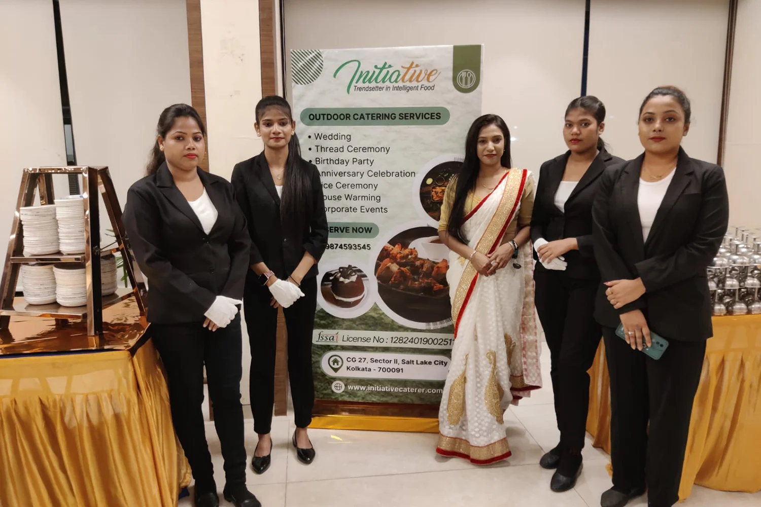 Catering event staff posing with service banner