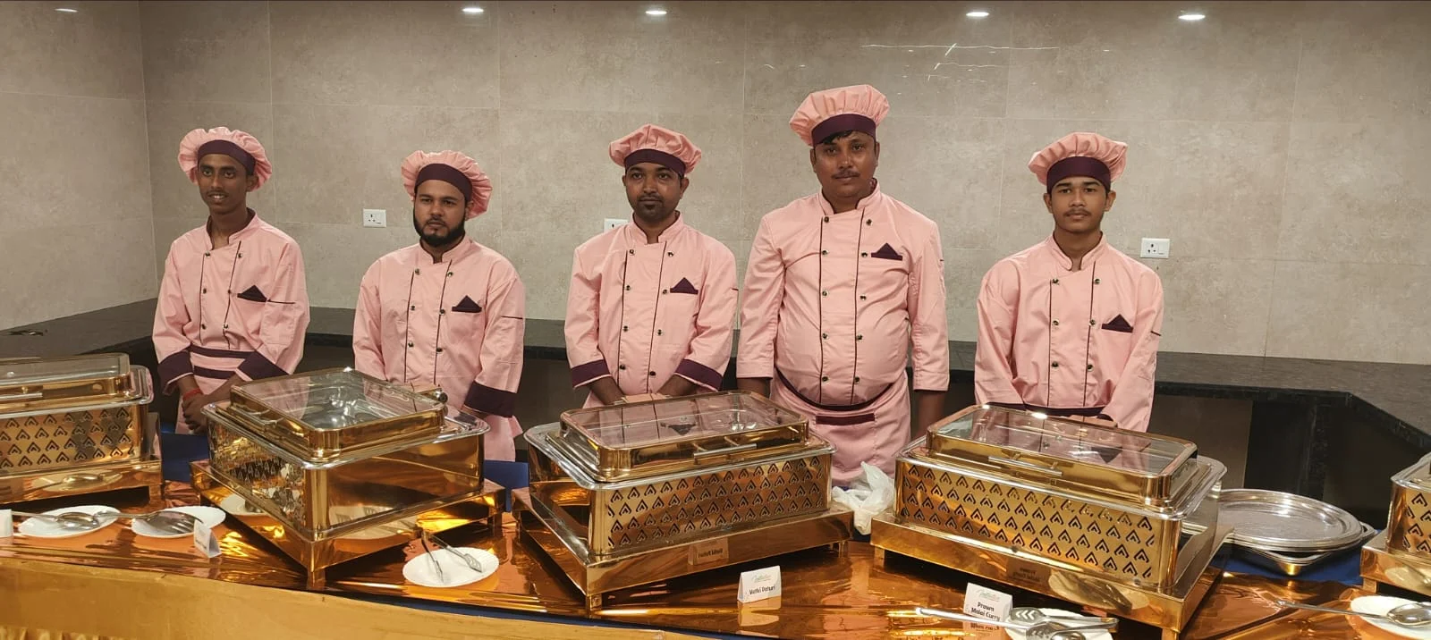 Catering staff serving buffet in pink uniforms